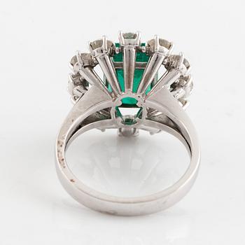 An emerald and round brilliant cut diamond ring.