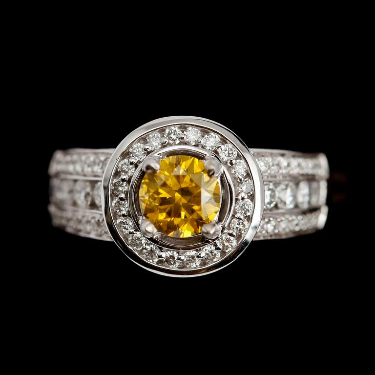 RING, 14 k vitguld, gul solitär briljantslipad diamant 0.84 ct samt mindre briljantslipade diamanter tot ca 1.0 ct.