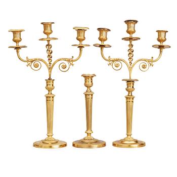 1440. A matched pair Empire early 19th century gilt bronze candelabra/candlesticks. Including one empire candlestick.