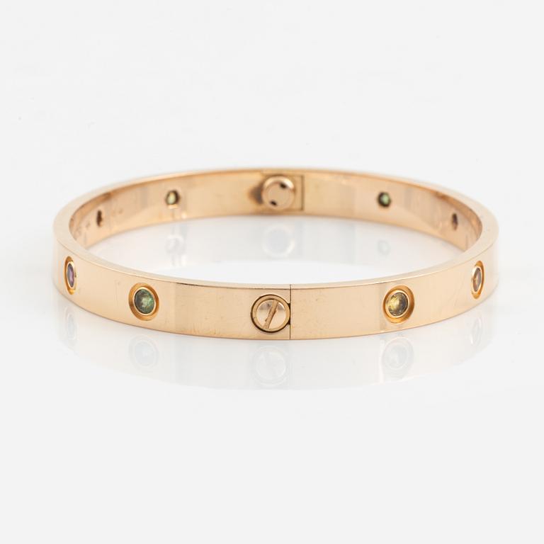 A Cartier "Love" bracelet in 18K rose gold set with colored stones.