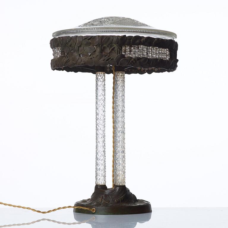 A Swedish Art Nouveau patinated brass and cut glass table lamp, Böhlmark's, Stockholm 1909-20.