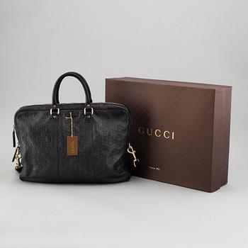 Gucci, a monogram leather bag/laptop-bag.