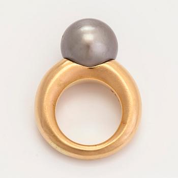 An 18K gold ring, with a cultured Tahiti pearl.