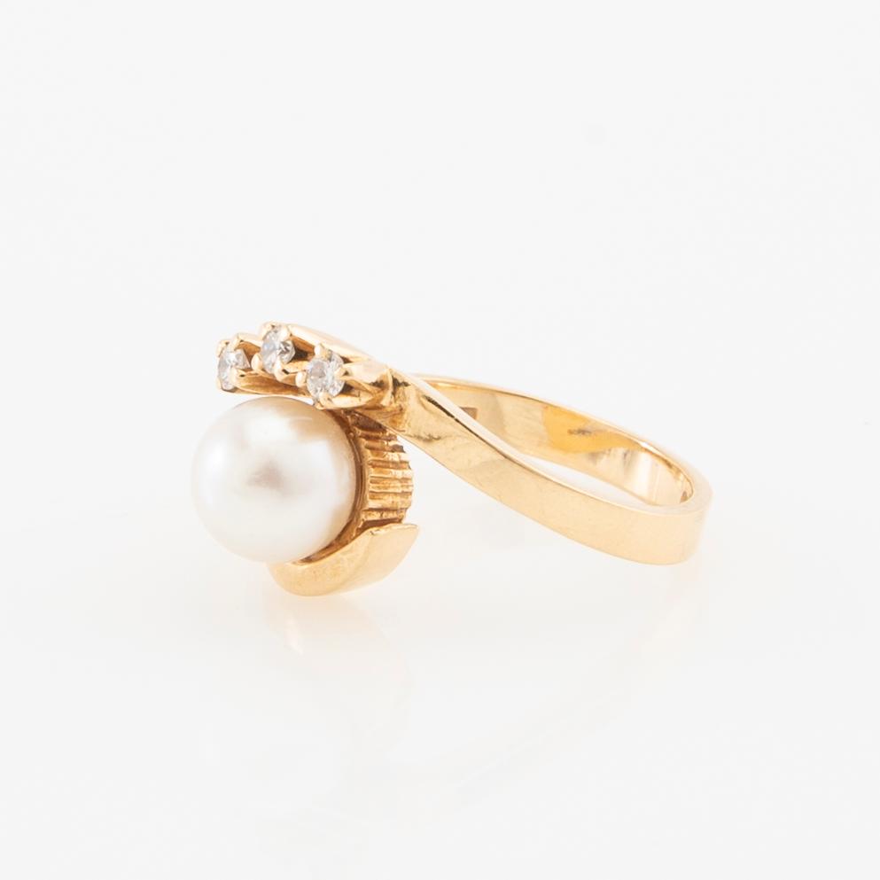 Ring in 18K gold set with round brilliant-cut diamonds and a cultured pearl.