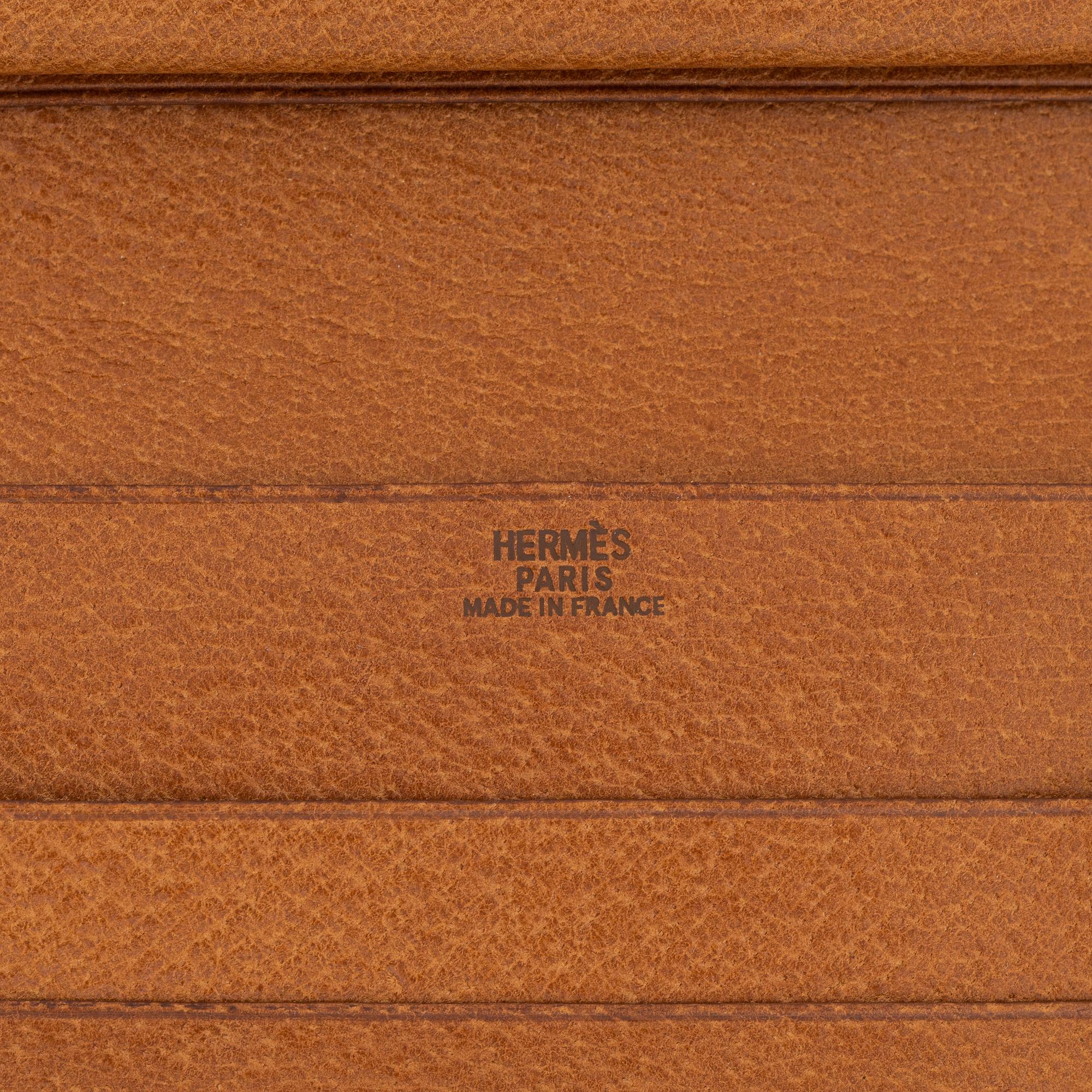 Hermès, a brown leather gold lock wallet.