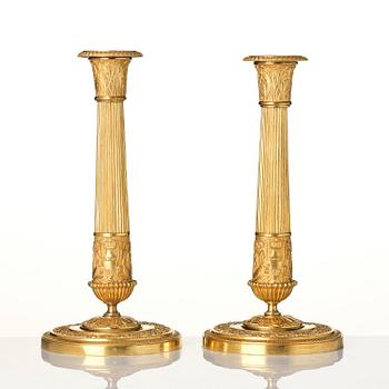 A pair of French Empire ormolu candlesticks, early 19th century.