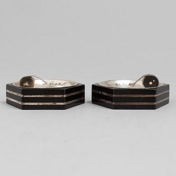 A set of two silver and ebony salt cellars with spoons by Guldsmedsaktiebolaget, Stockholm 1930-46.