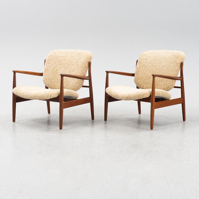 A pair of model FD 136 easy chairs with new sheepskin upholstery by Finn Juhl for France & Son, designed 1958.