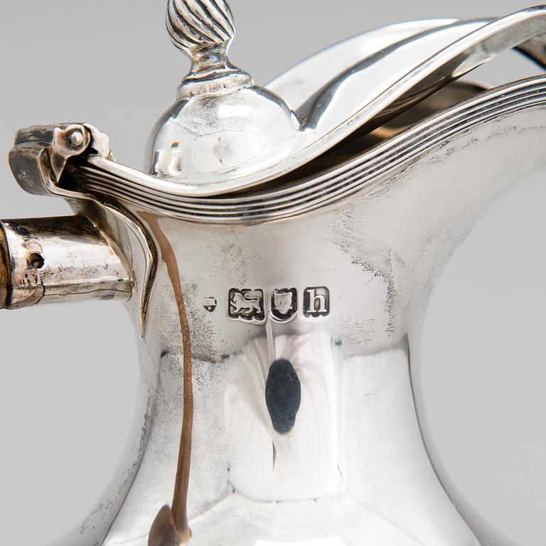 A sterling silver pitcher with wooden handle, London 1903.