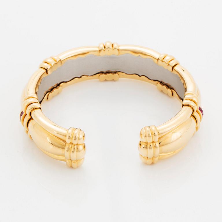 An 18K gold bracelet set with step-cut rubies.