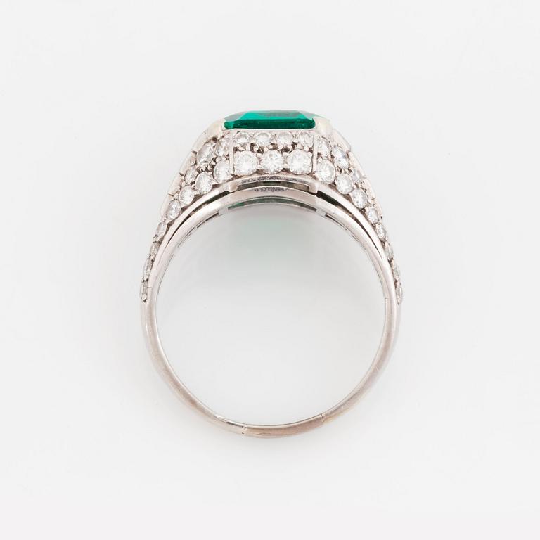 A Bulgari "Trombino" ring in platinum set with a step-cut emerald and round brilliant- and baguette-cut diamonds.