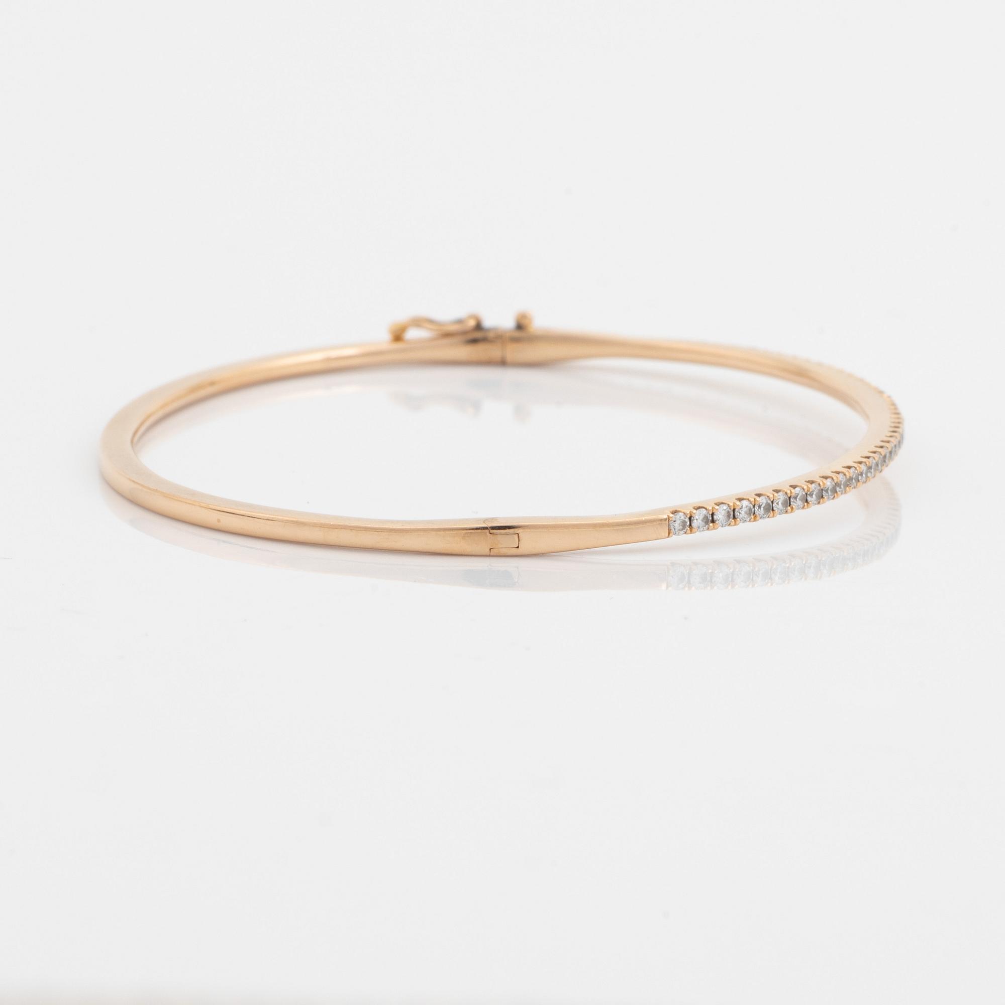 An 18K rose gold bangle set with round brilliant-cut diamonds.