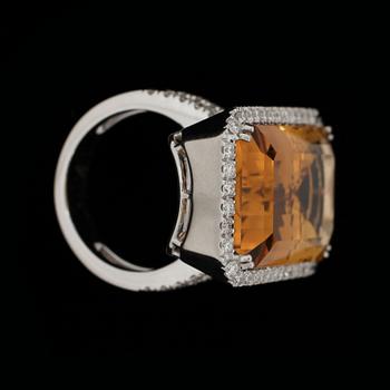 A step cut citrin ring, 25 cts, set with brilliant cut diamonds, tot 0.92 ct.
