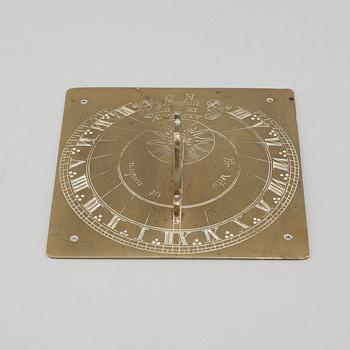 A brass sundial dated 1715.