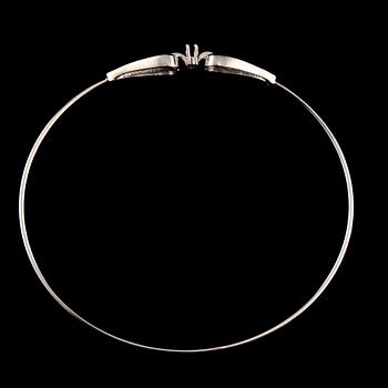 ARMRING, 18k vitguld med 2 åttkantslipade diamanter, 0.03 ct samt 2 fasettslipaded blå safirer. Vikt 6 g.