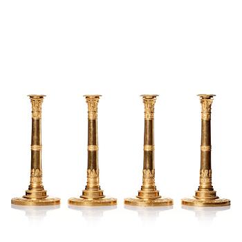 A set of four Empire presumably Russian candlesticks in gilded bronze.