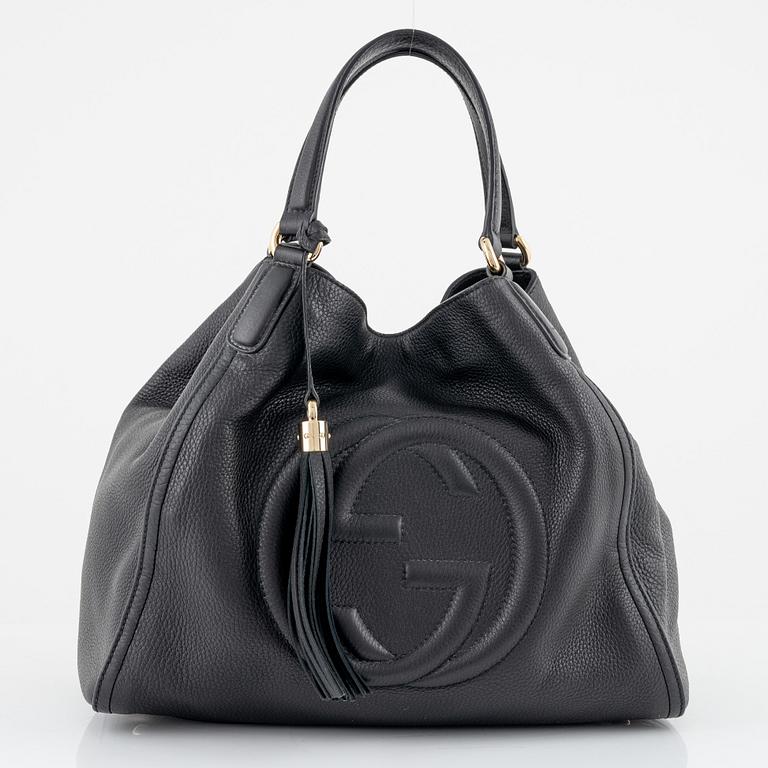 Gucci, a black leather handbag.