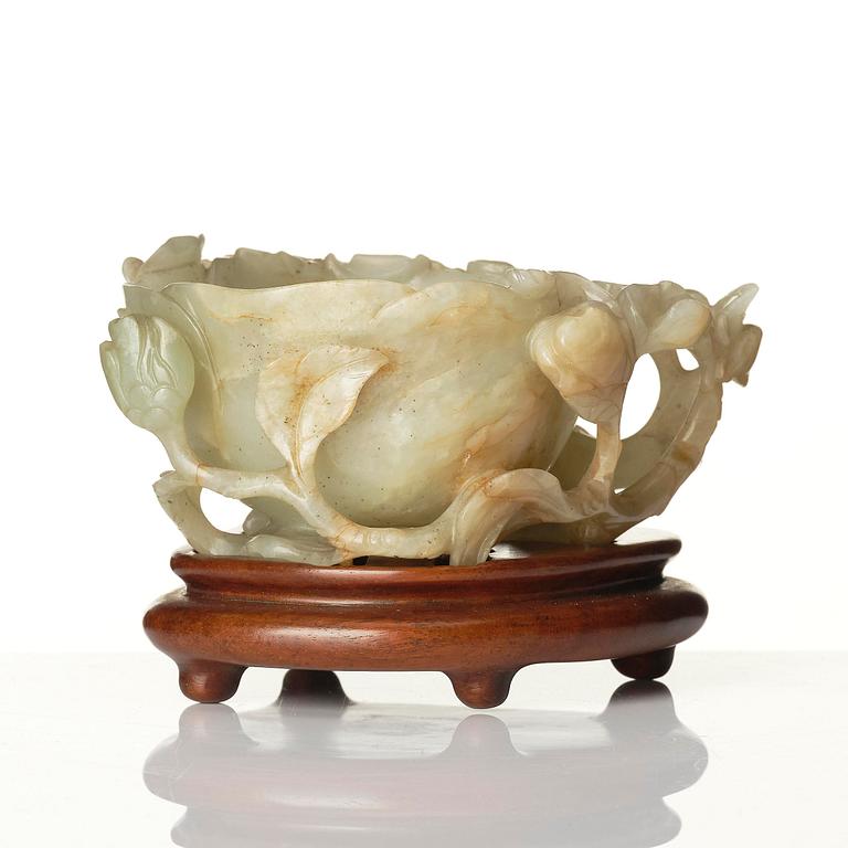 A carved Chinese nephrite cup in the shape of a lotus leaf, late Ming dynasty.