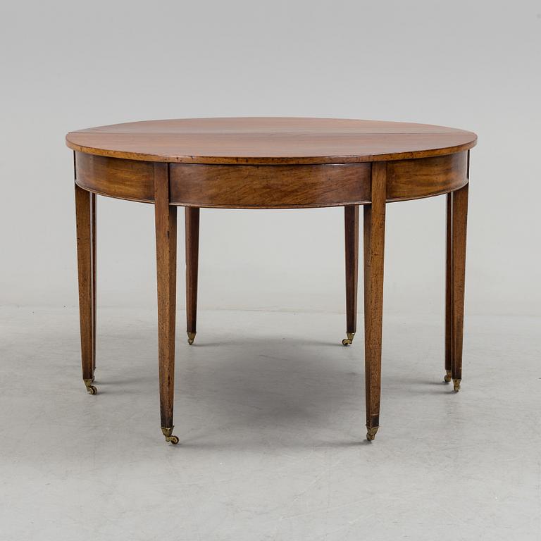 A English George III dining table veneerde with mahogany with two extension leafs from the late 18th century.