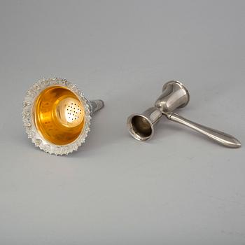 A silver plated wine strainer and a metal measurement second half of the 20th century.