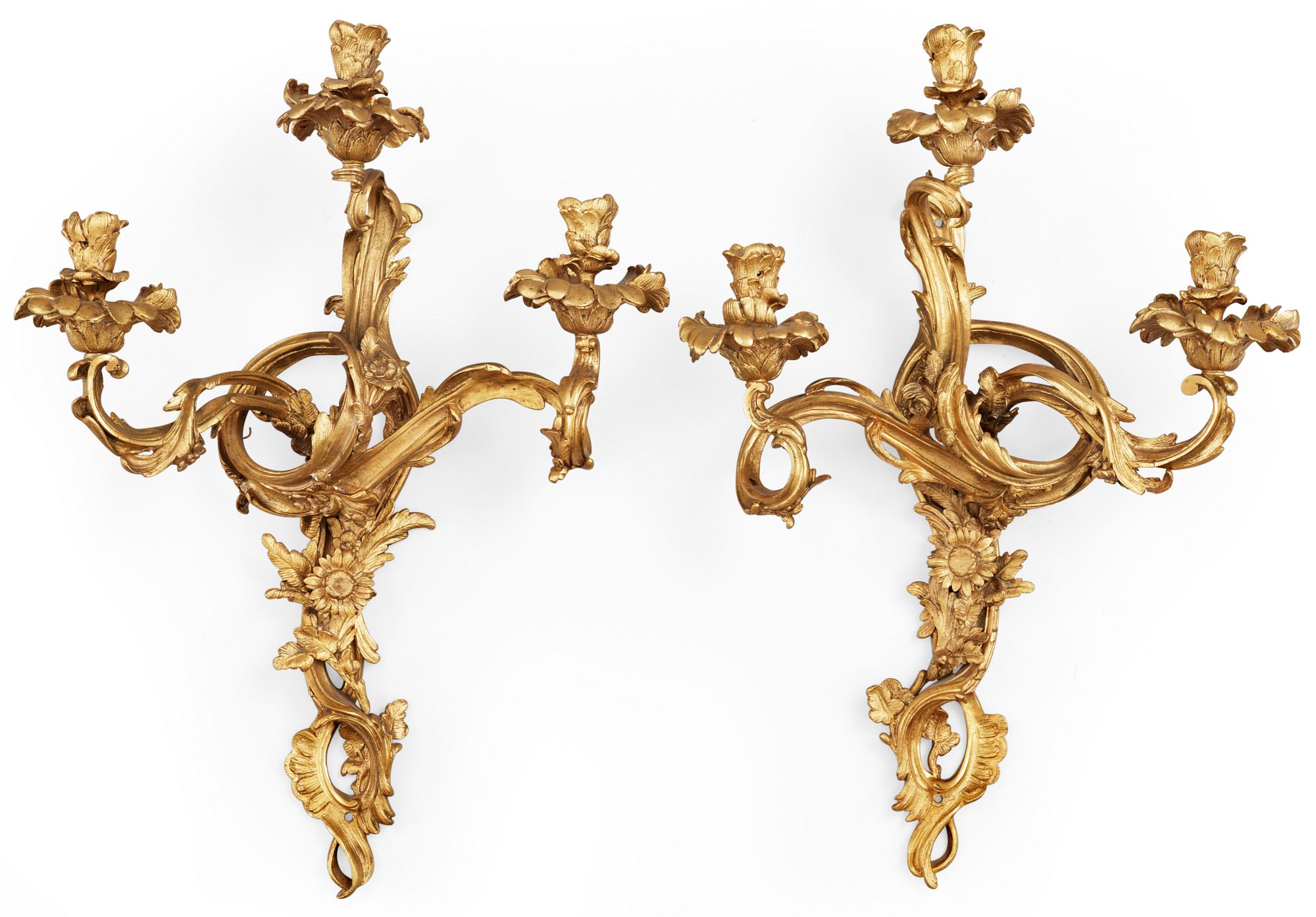 A pair of Louis XV-style late 19th century gilt bronze three-light wall-lights.
