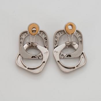 A pair of 18K white gold earrings set with round brilliant-cut diamonds.