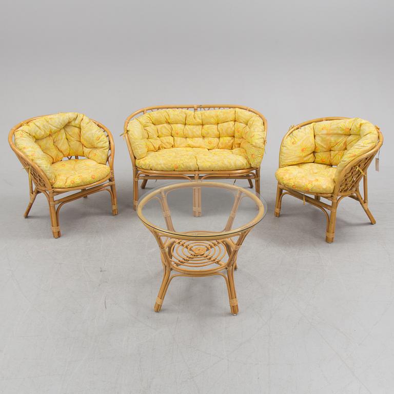 A 1970s four piece set of rattan garden furniture.