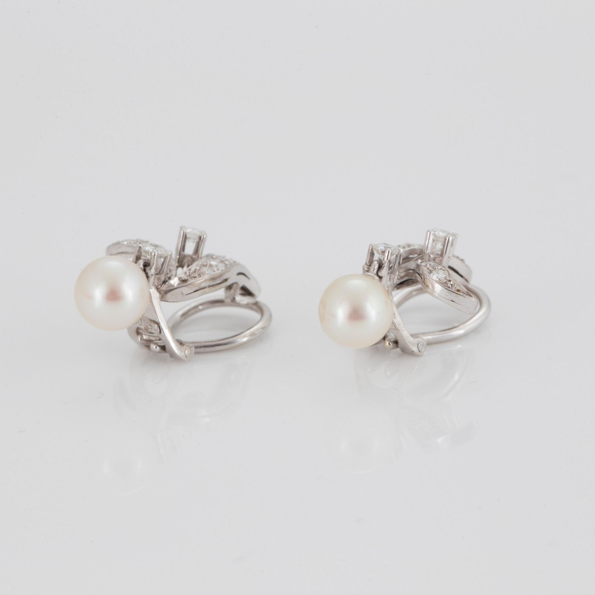 A pair of earrings set with eight- and round brilliant-cut diamonds and cultured pearls.