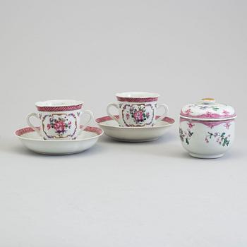 A pair of famille rose cup with stands and a sugar bowl with cover, Qing dynasty, Qianlong (1736-95).