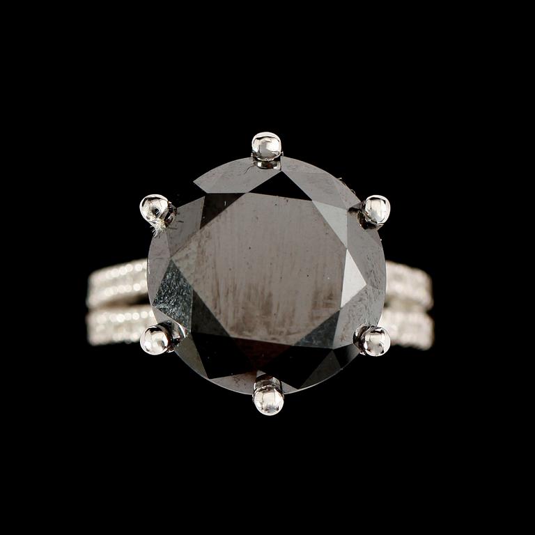 RING, 18 k vitguld, svart briljantslipad diamant 11.74 ct, samt 36 mindre briljanter tot ca 0.32ct.