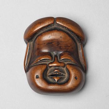 744. A Japanese netsuke in the shape of Okame, 19th Century.