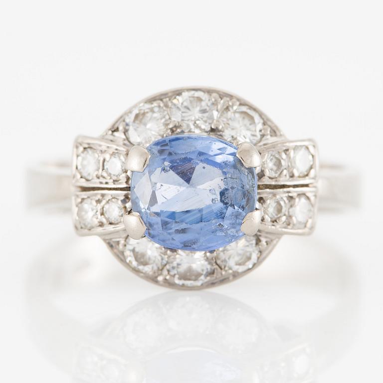 Ring 18K white gold set with a faceted sapphire and round brilliant-cut diamonds.