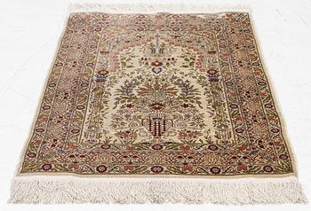 A silk Hereke rug, signed, c. 93 x 64 cm.