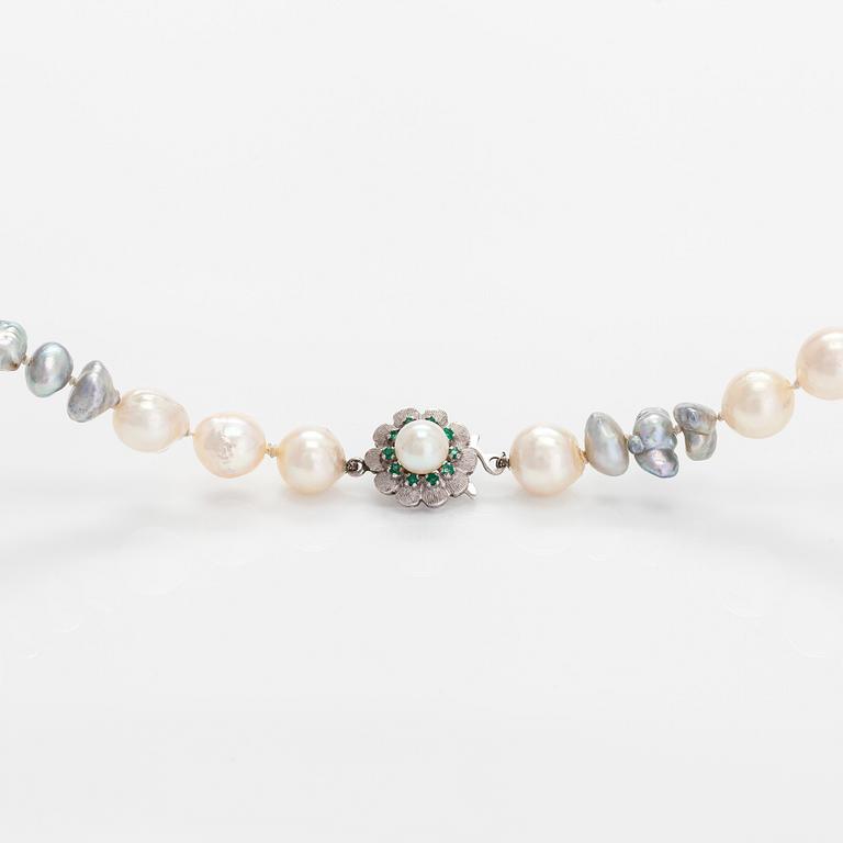 A cultured saltwater pearl necklace, clasp in 18K white gold with small emeralds.