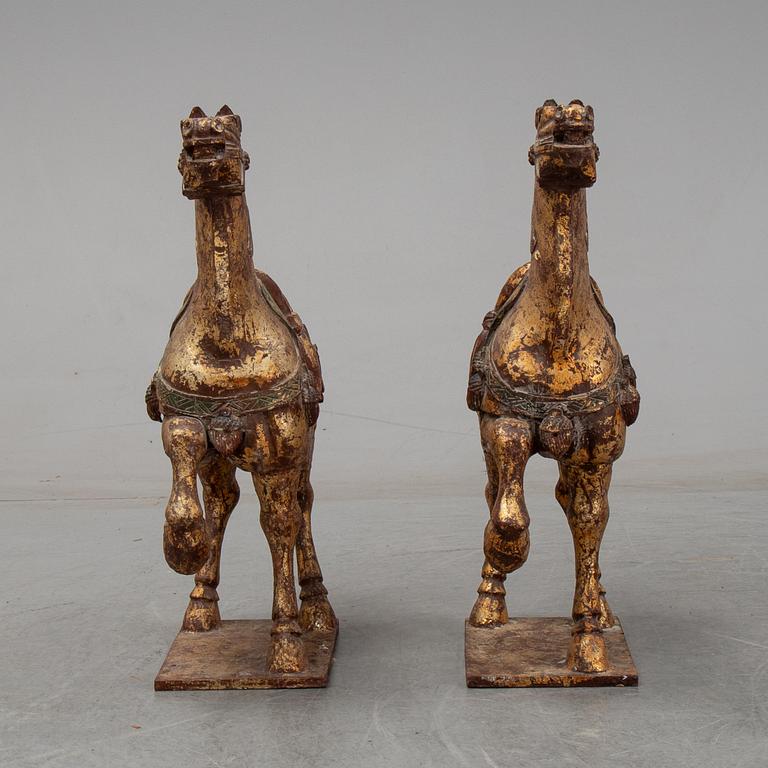 A pair of large Chinese wooden and gilt sculpture of horses, first half of the 20th century.