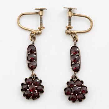 Garniture, necklace/bracelet and earrings in silver with garnets in the form of floral motifs, around the turn of the 20th century.