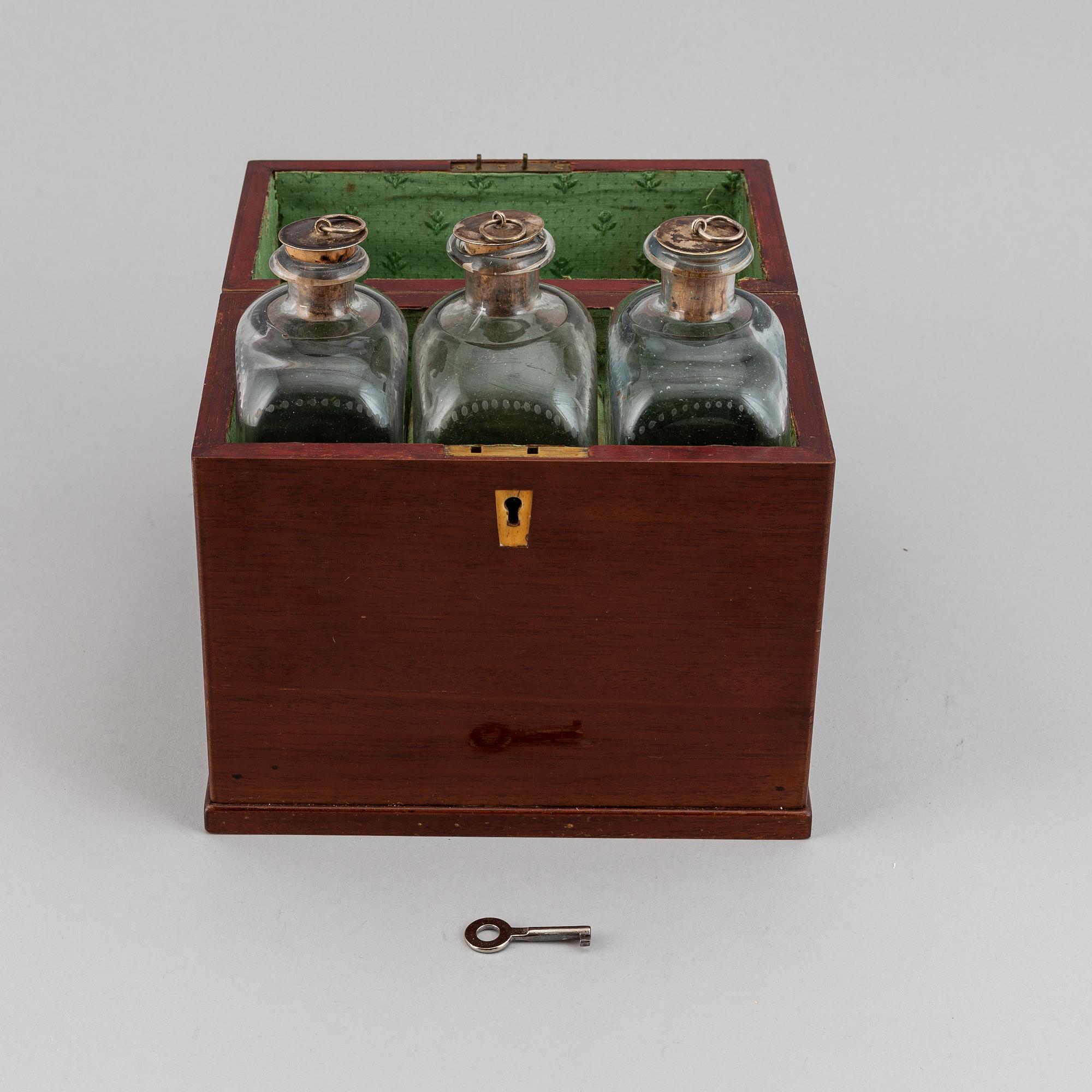 A late Empire mahogany box with three glass bottles, mid 19th Century.