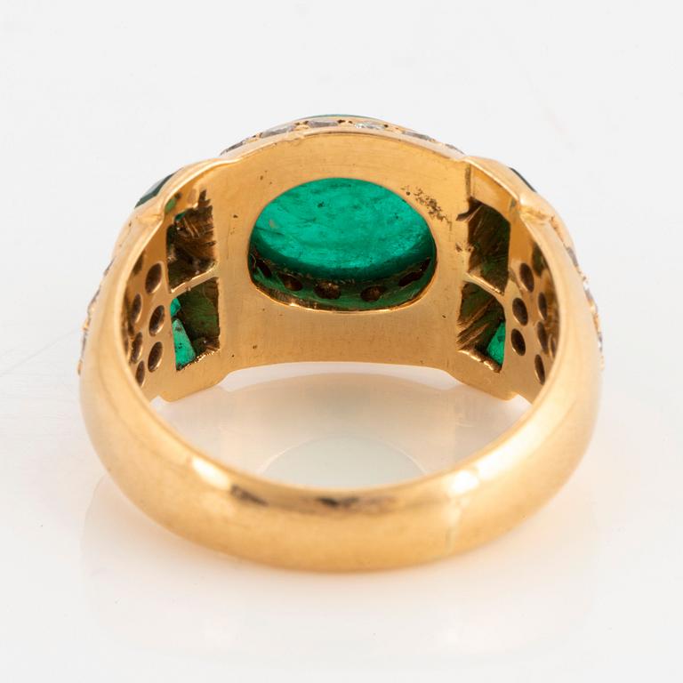 An 18K gold ring set with a cabochon-cut emerald.