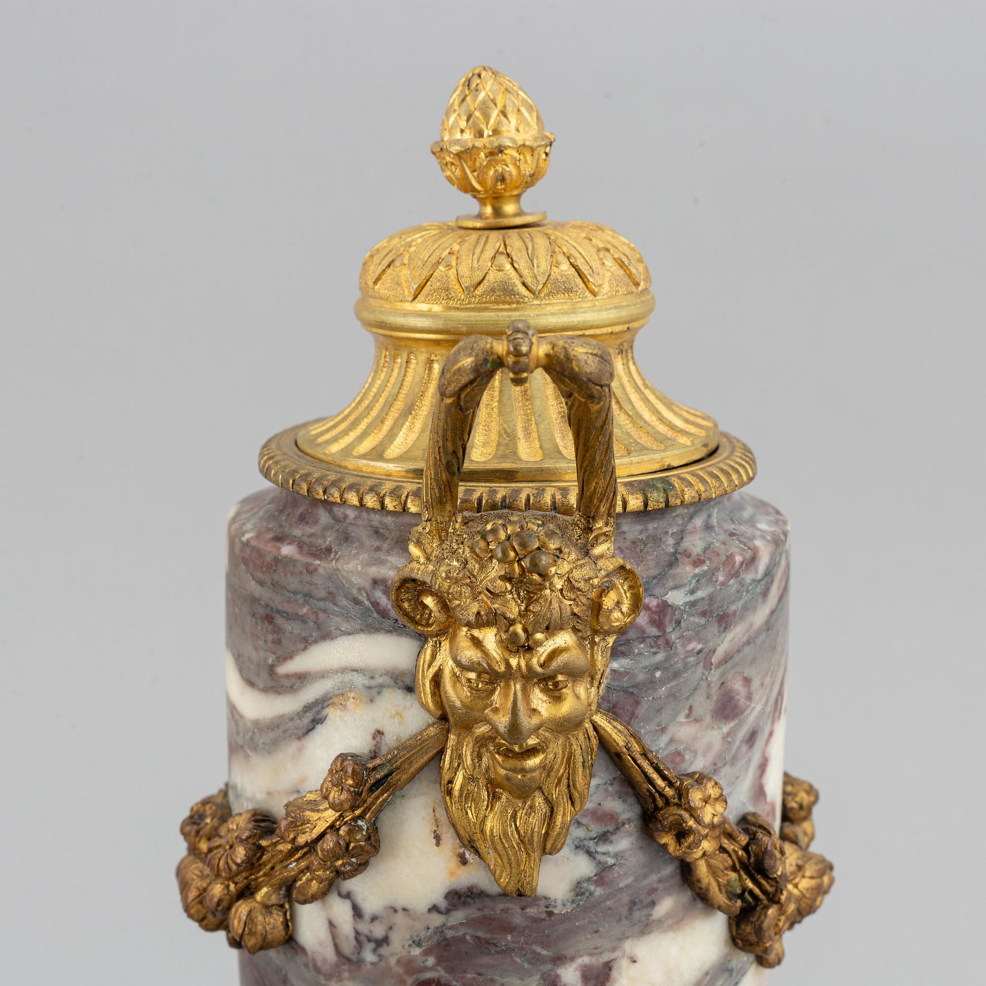 A pair of marble urns with bronze mountings from around year 1900.