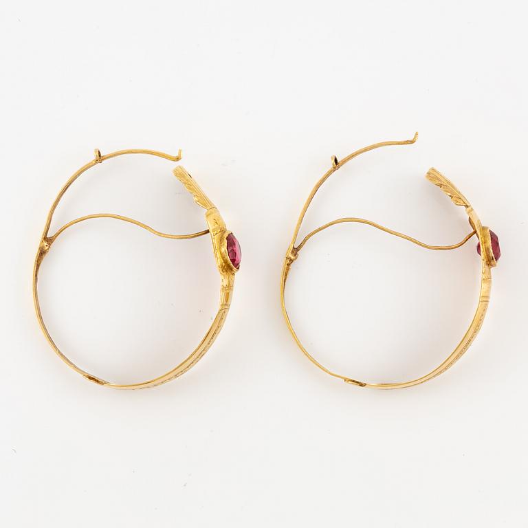 A pair of earrings in 18K gold with red glass, 9th century.