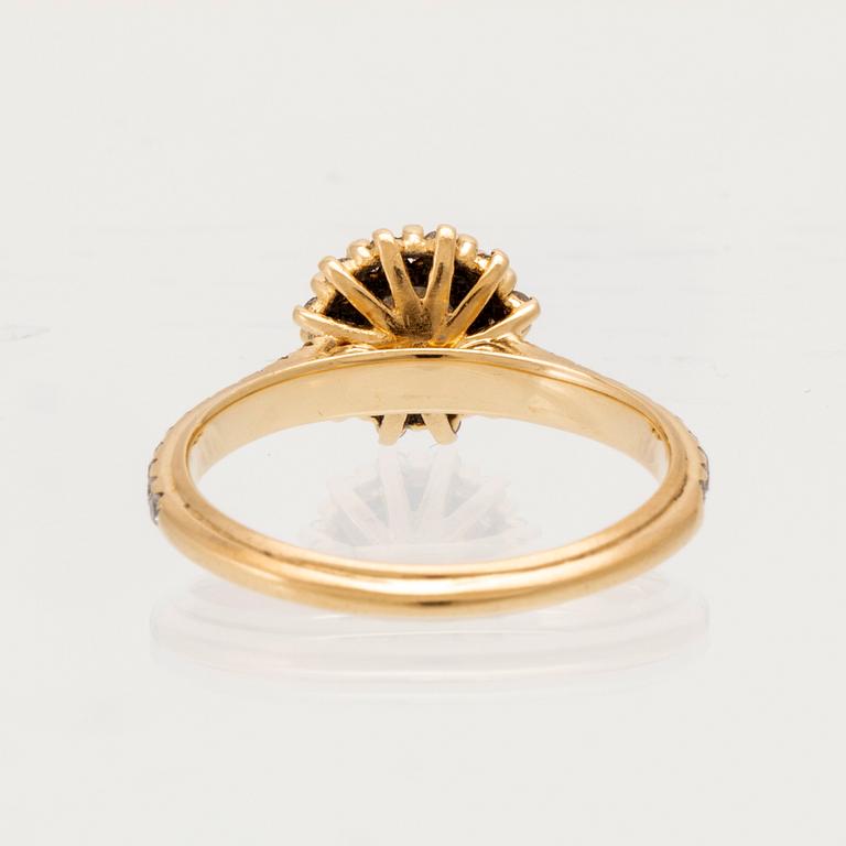 An 18K gold ring set with round brilliant-cut diamonds.