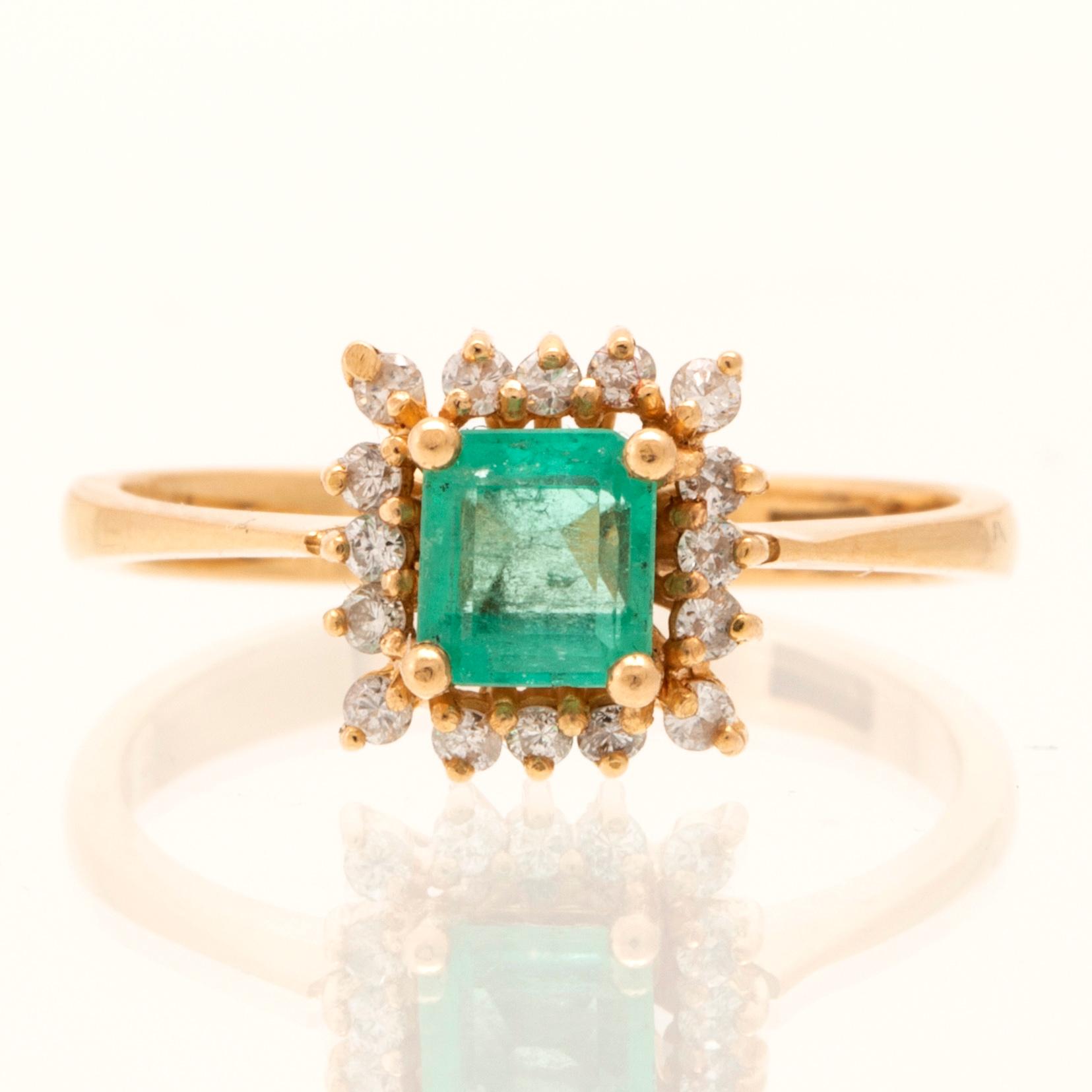 Ring in 18K gold with a step-cut emerald and round brilliant-cut diamonds.