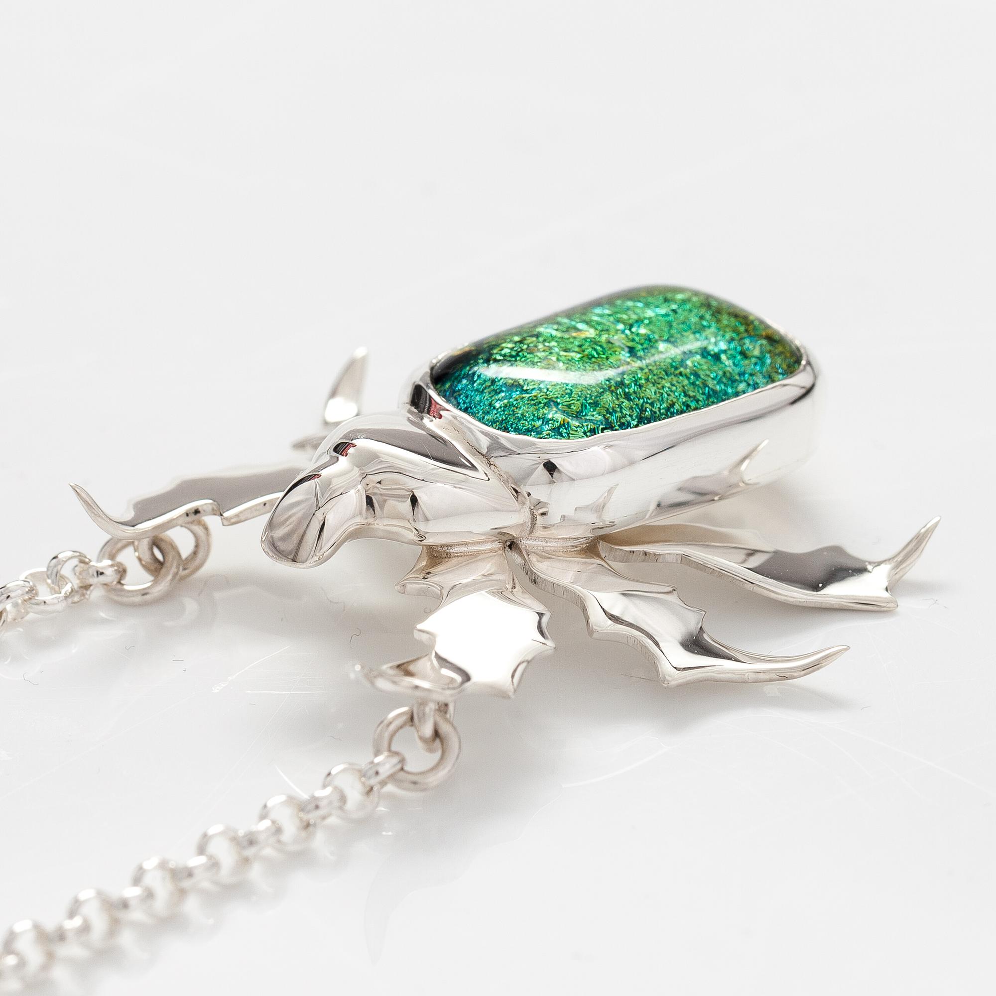 A sterling silver necklace "Gold beetle" with dichroic glass. Ru Runeberg 2019.