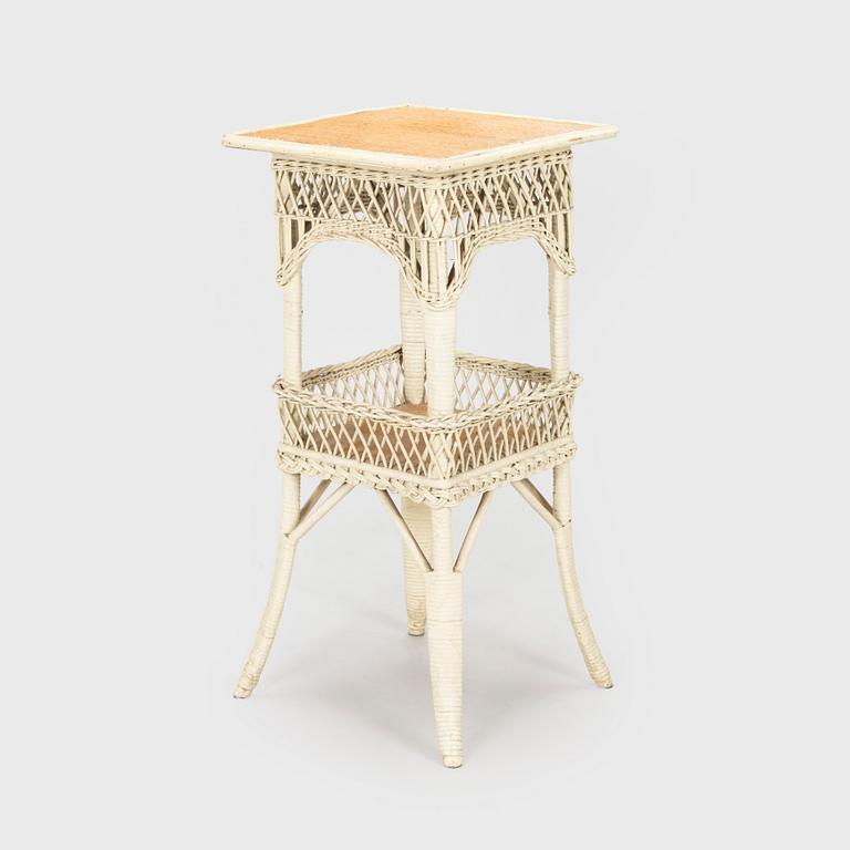 A mid-20th-century three-piece rattan furniture set including two armchairs, and a table.