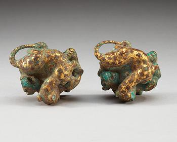 A pair of gilt bronze archaistic weights.