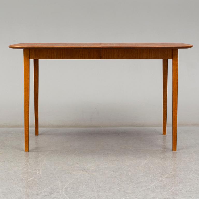 A late 20th Century teak veneered dinner table.