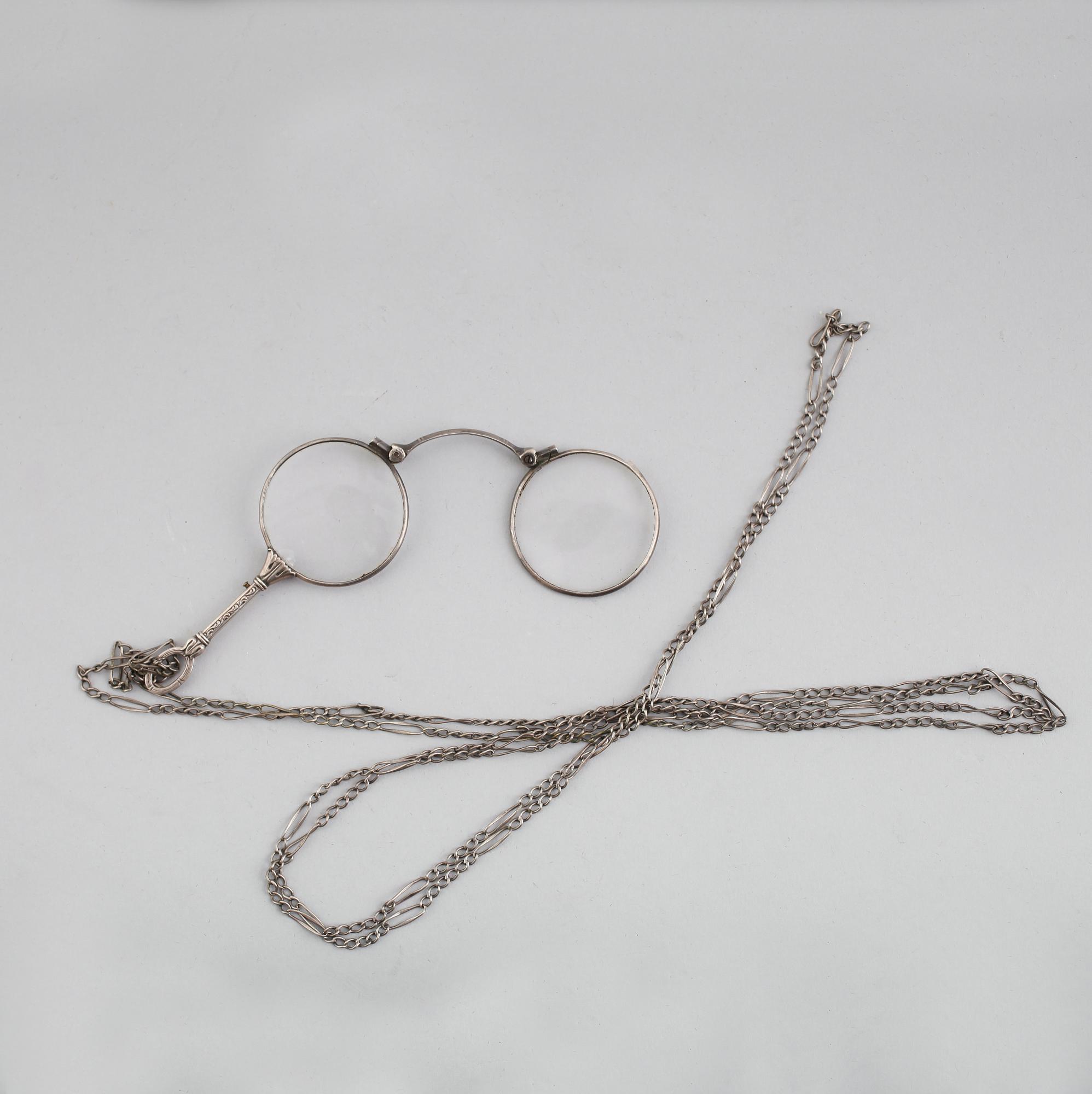 LORGNETTE MED KEDJA, silver, omkring år 1900.