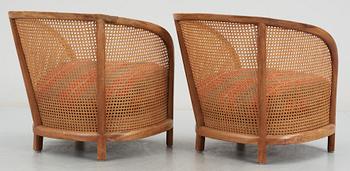 A pair of Oscar Nilsson beech and rattan arm chairs.