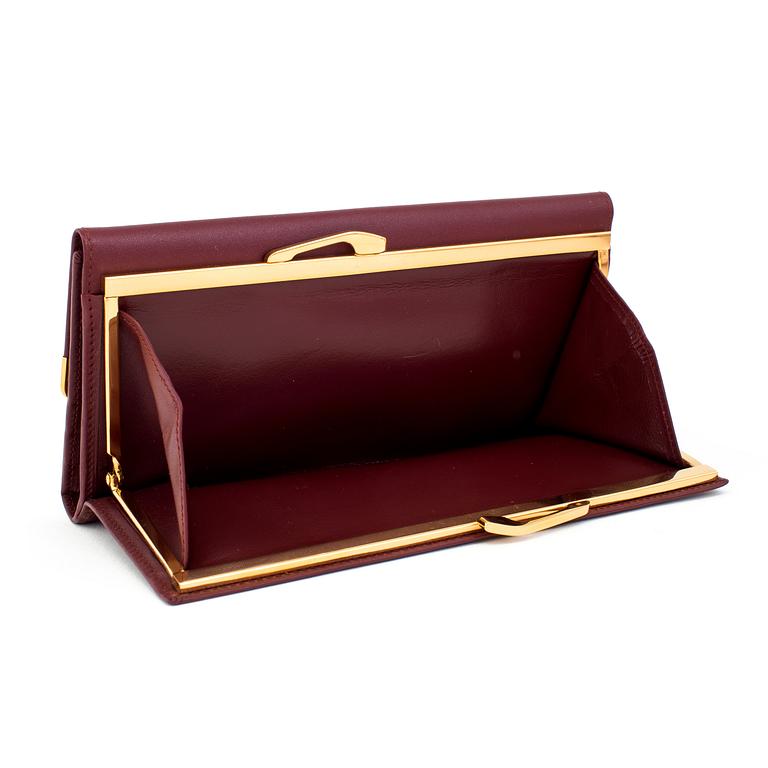 A clutch and a wallet by Cartier.