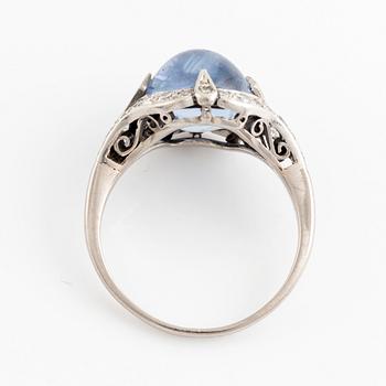 An 18K gold ring set with a cabochon-cut sapphire and eight-cut diamonds.